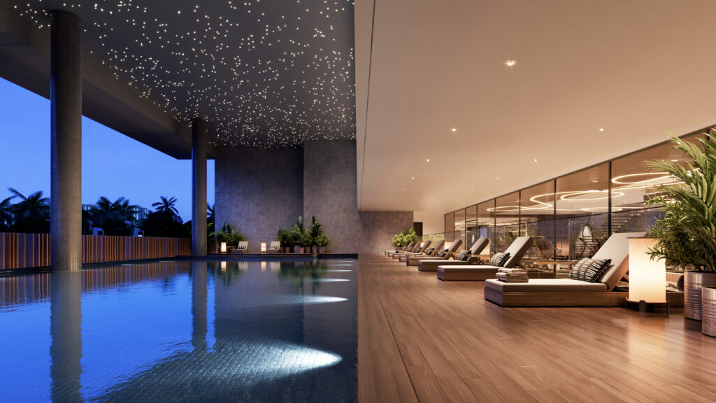 A luxurious indoor swimming pool area at night featuring a ceiling with starry light effects. The space includes comfortable lounge chairs on a wooden deck next to calm blue water.