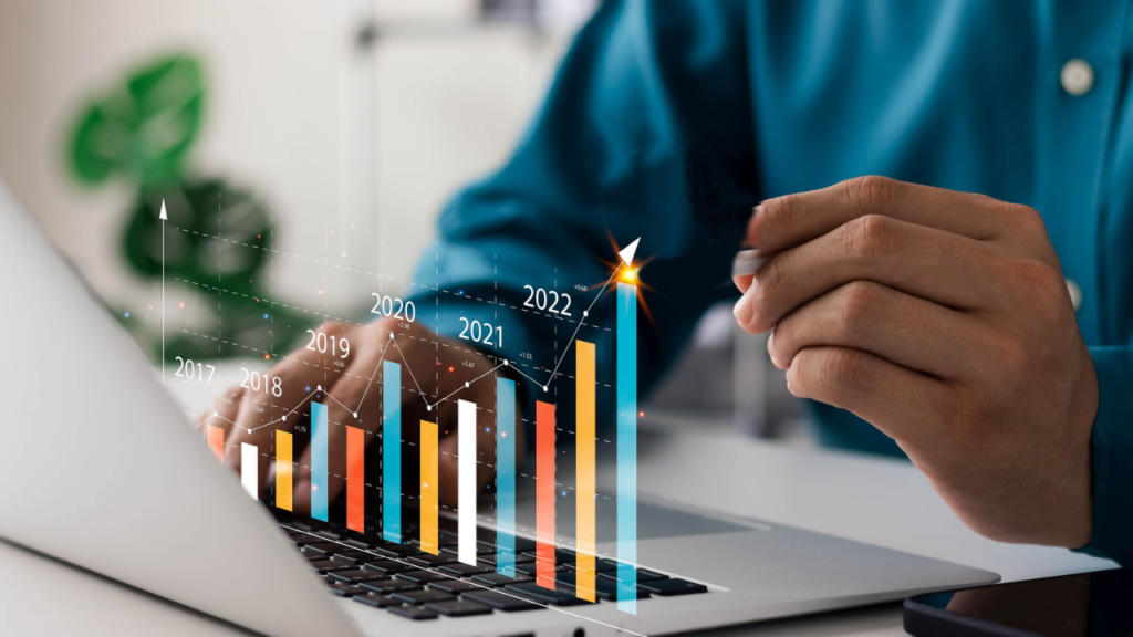A flat-design graphic showing stacked gold coins, a hand holding upward-pointing green and orange arrows, and a central coin with a percent sign, symbolizing market growth and high ROI potential.